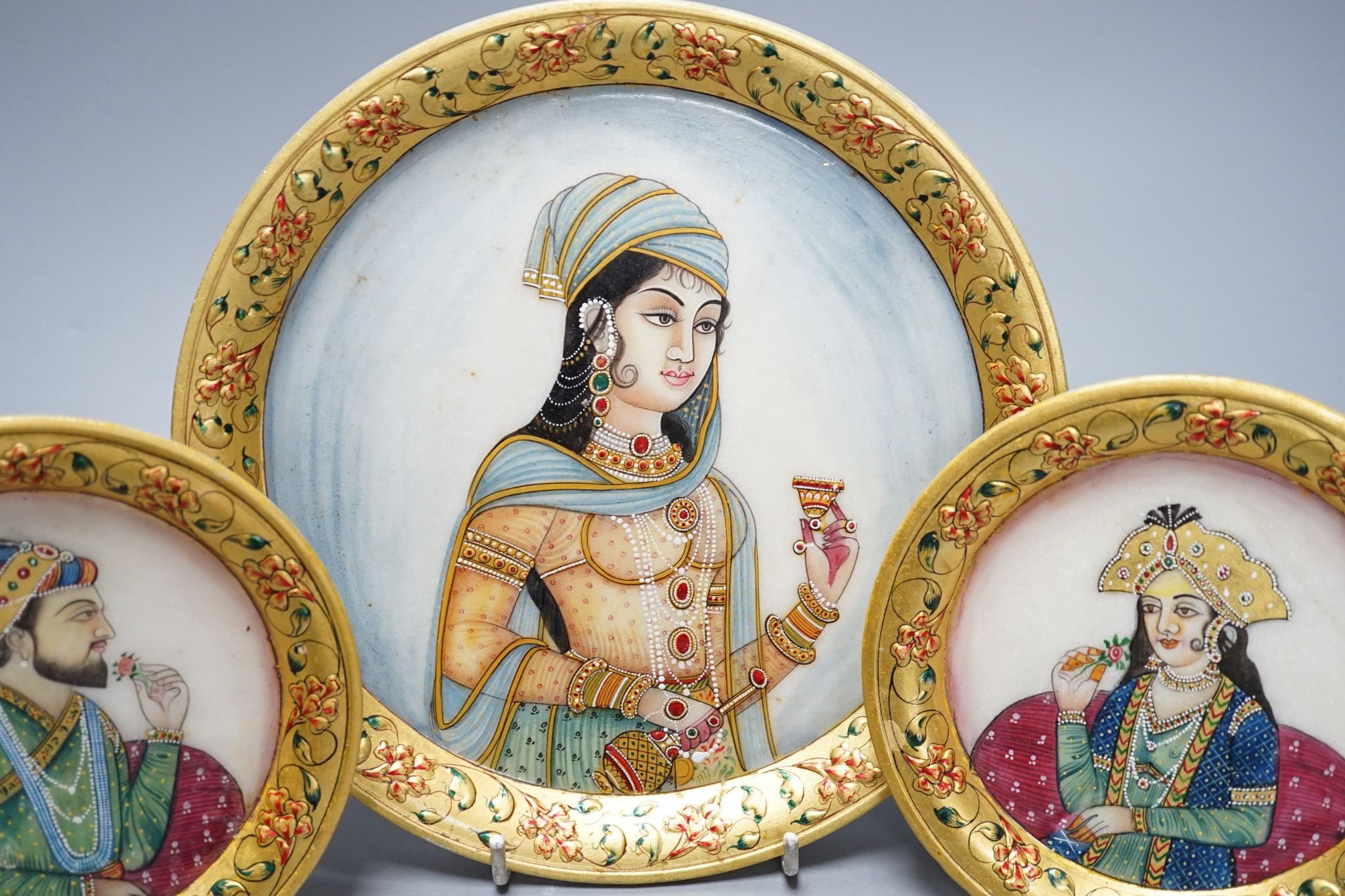 Three Indian alabaster, gilt bordered plates depicting Indian Royalty, 22cm